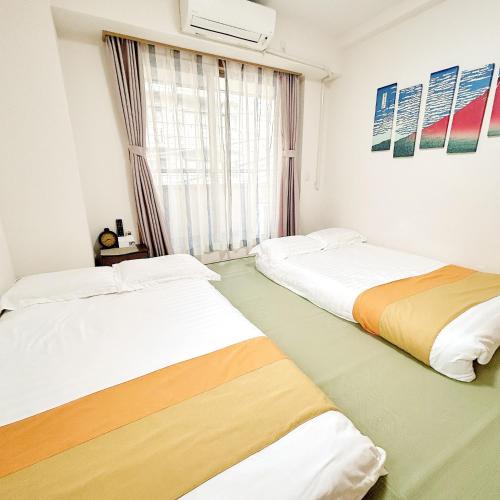 deux lits dans une chambre avec une fenêtre dans l'établissement LuckyHouse浅草 成田羽田直行, à Tokyo