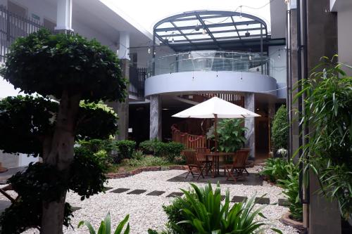 a courtyard with a table and an umbrella in a building at Grand Samota Hotel in Sumbawa Besar