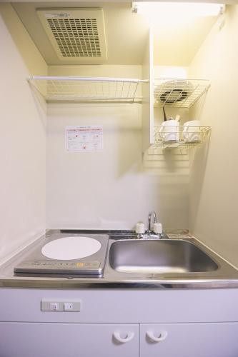 a kitchen with a sink and a counter top at Tookin house 池袋 in Tokyo