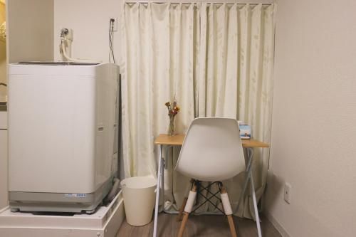 TV e sedia in camera con tenda di Tookin house 池袋 a Tokyo