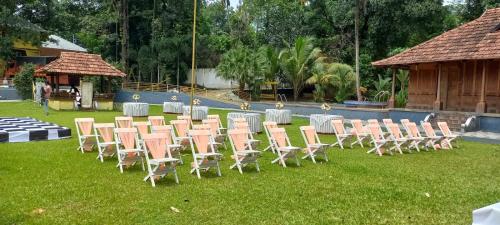 a group of chairs and tables and a table and chairsearcher at Sparrow Vale Resort in Kotamangalam