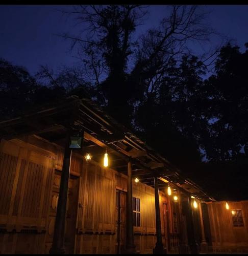 a house with lights on the side of it at night at Sparrow Vale Resort in Kotamangalam