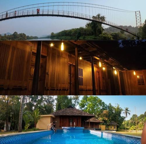 a bridge over a swimming pool and a building at Sparrow Vale Resort in Kotamangalam