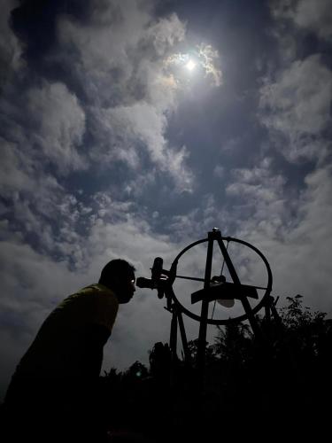 a man is looking at the sun through a telescope at Carabao Island Observatory and Think Tank in San Jose