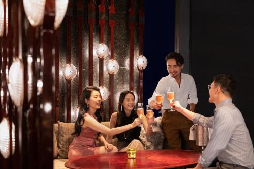 a group of people sitting around a table with drinks at Shangri-La Nanning - The tallest hotel worldwide in Shangri-La Group in Nanning