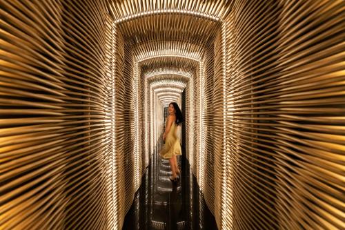 a woman walking through a tunnel of lights at Shangri-La Nanning - The tallest hotel worldwide in Shangri-La Group in Nanning