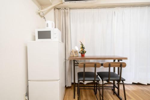 una piccola cucina con tavolo e frigorifero di Tookin house 池袋 a Tokyo
