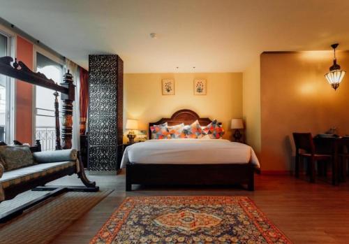a bedroom with a large bed and a couch at SHEIK ISTANA HOTEL CHIANGMAl in Chiang Mai