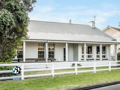 a white house with a white fence in front of it at Summer Lodge-Esplanade frontage Character & charm in Victor Harbor