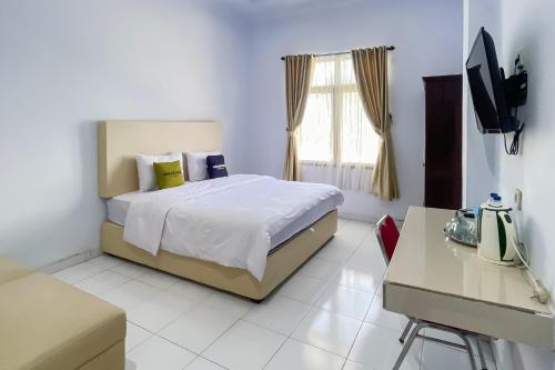 a bedroom with a bed and a television in it at Urbanview Hotel Grand Seven One Kota in Manna