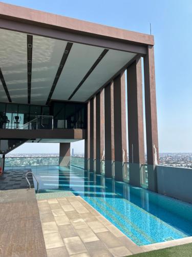 a swimming pool on the roof of a building at BTS Bearing 23Fl 68sqm condo with open city view Shared rooftop and gym in Samut Prakan