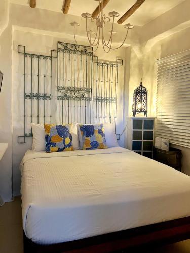 a bedroom with a large white bed with a chandelier at Lugar Bonito Hotel in Boracay