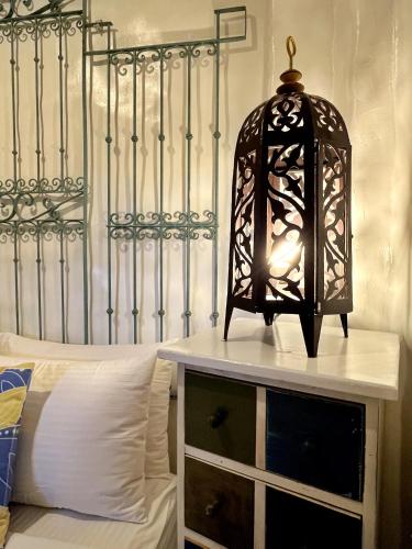 a black lamp on a dresser next to a bed at Lugar Bonito Hotel in Boracay