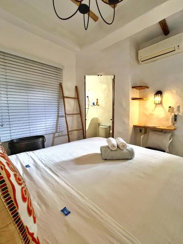 a bedroom with a large white bed with two towels on it at Lugar Bonito Hotel in Boracay