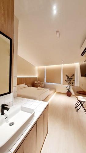 a bathroom with a sink and a bed in a room at Kazuki Boutique Accommodation in George Town