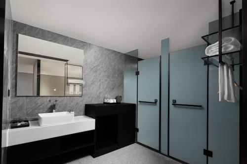 un baño con lavabo y espejo en m designer hotel, en Dujiangyan