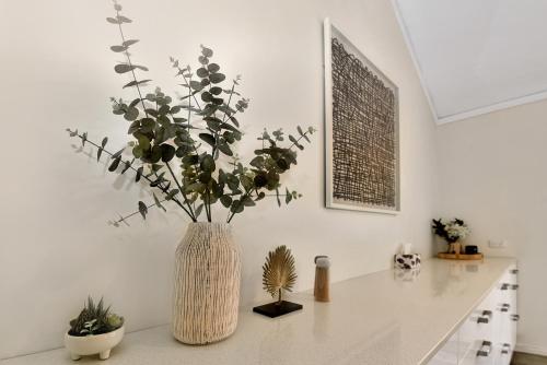 a vase with flowers on a counter in a kitchen at Blissful Silver Sands Retreat - Aldinga Beach - C21 SouthCoast Holidays in Aldinga Beach