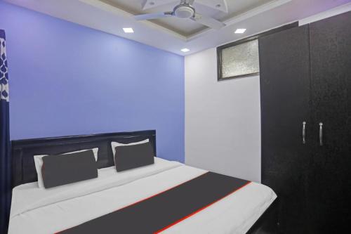 a bedroom with a bed and a blue wall at Hotel N R Prime Royalty Greater Kailash - Couple Friendly in New Delhi