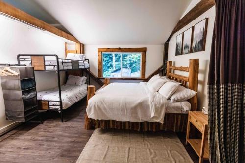 a bedroom with a bed and two bunk beds at Log Cabin with King Bed and Hot Tub in Ashford