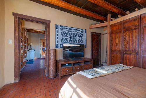 a bedroom with a bed and a tv on a wall at Canyon Getaway- Courtyard, Canyon Rd & Plaza, 1BR in Santa Fe