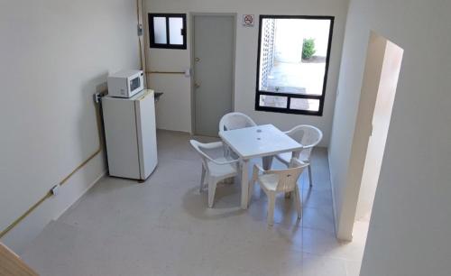 a small kitchen with a table and a refrigerator at Casa San Andres in Tzompantepec