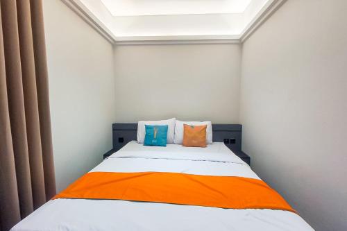 a bedroom with a bed with two pillows on it at Sans Hotel Bogor in Bogor
