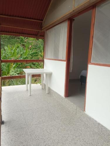 a white table sitting on the outside of a building at HOSTAL MIRADOR dentro del parque tayrona in El Zaino