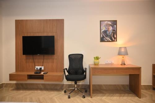 a room with a desk and a chair and a television at Arunachal Bhawan in Tinsukia