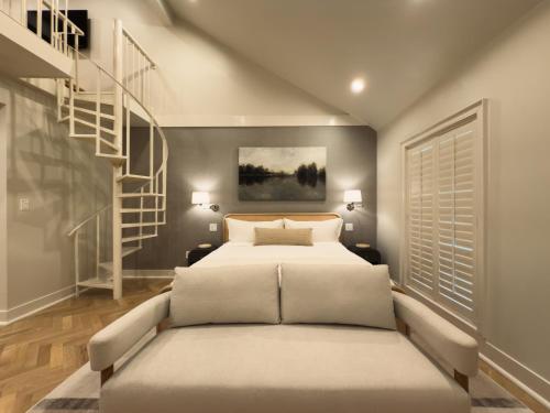 a bedroom with a bed and a staircase at Garden District Hotel in New Orleans