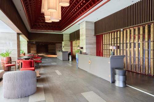 eine Bibliothek mit roten Stühlen, Tischen und Büchern in der Unterkunft The Apec Mandala Ocean View Mui Ne - Condotel in Mui Ne