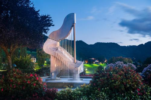 a statue of a harp in a park at night at Wellness Landhaus Parth in Ossiach