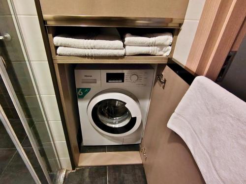 a washing machine in a bathroom with towels at Infinity Tower apartments Batumi in Batumi