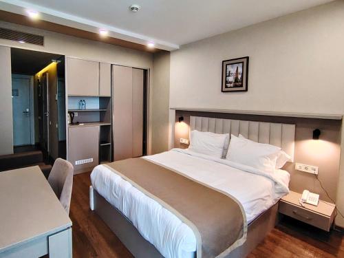 a bedroom with a large bed and a kitchen at Infinity Tower apartments Batumi in Batumi