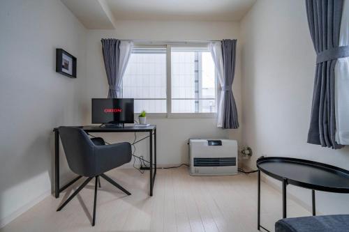 a room with a desk with a computer and a chair at Court Villa Sapporo 403 in Sapporo