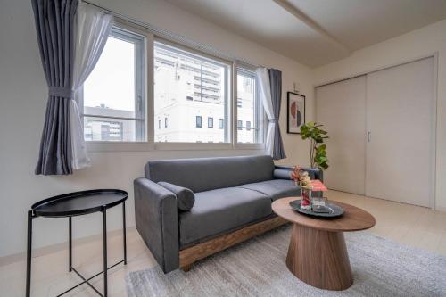 a living room with a couch and a table at Court Villa Sapporo 403 in Sapporo