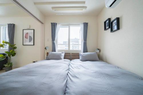 two beds in a room with a window at Court Villa Sapporo 403 in Sapporo