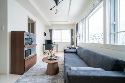a living room with a blue couch and a table at Court Villa Sapporo 403 in Sapporo