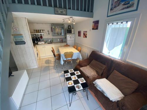 un salon avec un canapé et une table dans l'établissement Agréable maisonnette avec jardin, piscine collective, proche mer - FR-1-194-291, à La Faute-sur-Mer