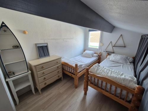 - une chambre avec 2 lits jumeaux et un miroir dans l'établissement Agréable maisonnette avec jardin, piscine collective, proche mer - FR-1-194-291, à La Faute-sur-Mer