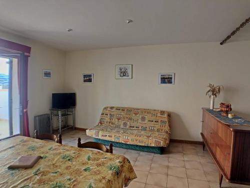 - une chambre avec 2 lits, une commode et une télévision dans l'établissement Appartement pour 4 pers. avec cour privative aux Saintes-Maries-de-la-Mer - FR-1-475-210, à Saintes-Maries-de-la-Mer
