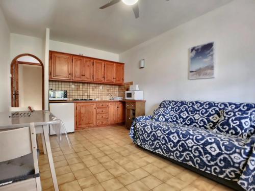 un salon avec un canapé et une cuisine dans l'établissement Appartement calme pour 4, avec terrasse et WIFI, Saintes-Maries-de-la-Mer - FR-1-475-211, à Saintes-Maries-de-la-Mer