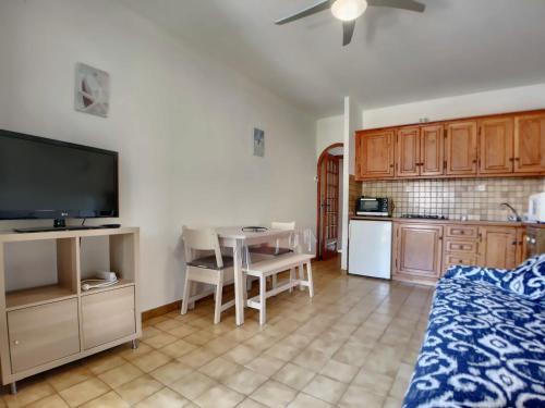 un salon avec une cuisine et une table avec une télévision dans l'établissement Appartement calme pour 4, avec terrasse et WIFI, Saintes-Maries-de-la-Mer - FR-1-475-211, à Saintes-Maries-de-la-Mer