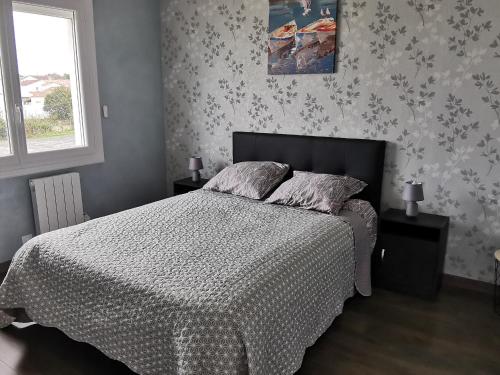 une chambre avec un lit avec une couette et une fenêtre dans l'établissement Grande maison indép. 4 ch. à 600m plage, animaux admis - FR-1-194-292, à La Tranche-sur-Mer