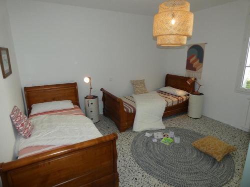 une chambre avec deux lits et un tapis dans l'établissement Maison rénovée à Notre Dame de Monts, 4 pers, proche plage - FR-1-540-317, à Notre-Dame-de-Monts