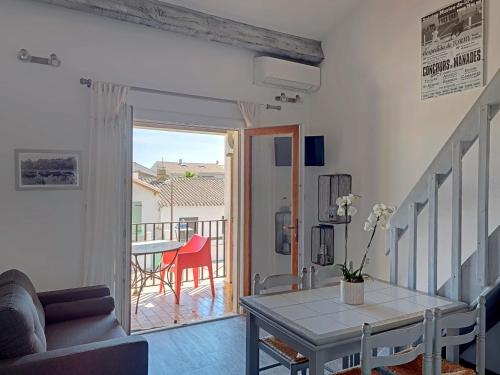 d'un salon avec une table et un balcon. dans l'établissement Duplex rénové avec climatisation près de la mer - FR-1-475-213, à Saintes-Maries-de-la-Mer