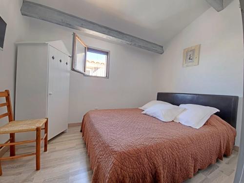 une chambre avec un lit, une chaise et une fenêtre dans l'établissement Duplex rénové avec climatisation près de la mer - FR-1-475-213, à Saintes-Maries-de-la-Mer