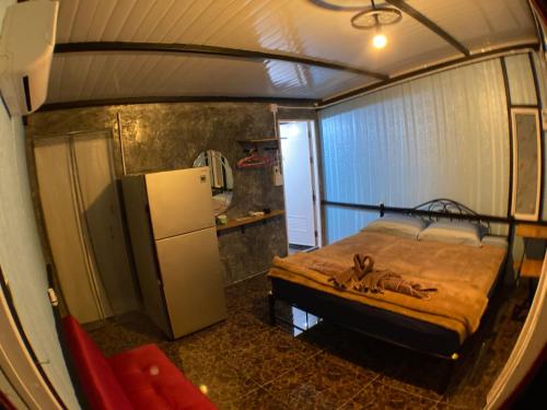 ein kleines Schlafzimmer mit Bett und Kühlschrank in der Unterkunft PinkHouse in Ban Bang Bao