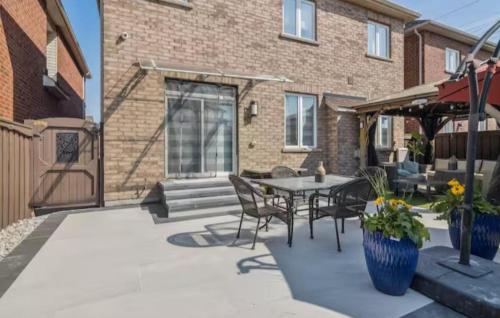 a patio with a table and chairs and a building at Comfortable & Cozy 2BR Hideaway Basement Appartment in Brampton