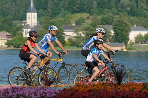 a group of people riding bikes in the water at Wellness Landhaus Parth in Ossiach