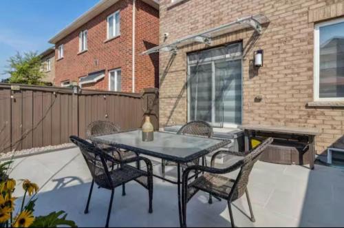 a patio with a table and chairs and a fireplace at Comfortable & Cozy 2BR Hideaway Basement Appartment in Brampton